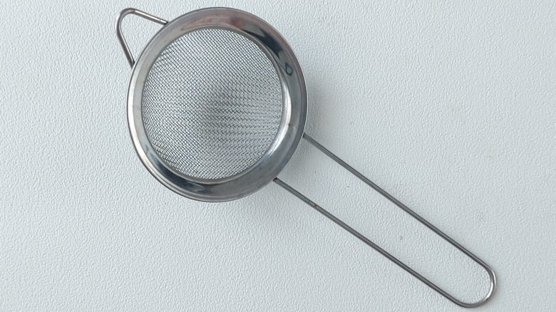 A handheld strainer
