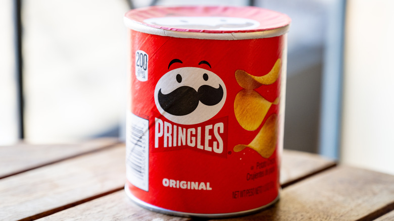 A small can of Pringles original on a wooden table