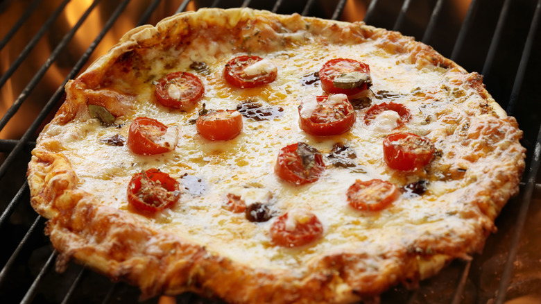 Pizza on fiery grill
