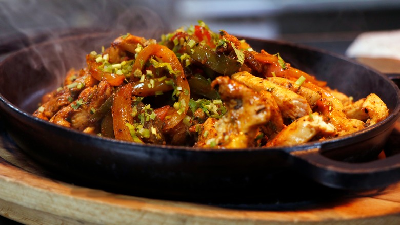 Grilled chicken fajita sizzling in pan