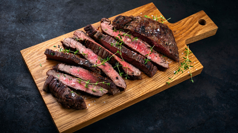 Cooked flank steak on wood board