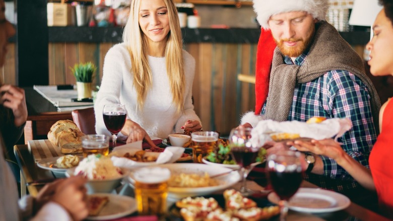 santa hat-wearing man and friends dining