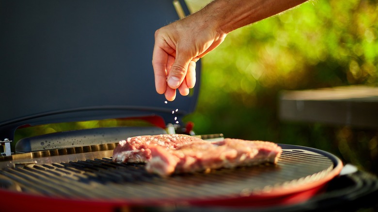 Seasoning meat on a grill