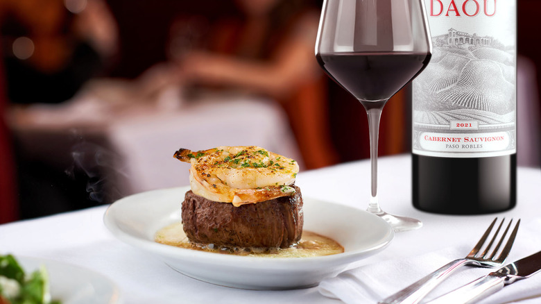 Steak with shrimp and wine pairing on dinner table