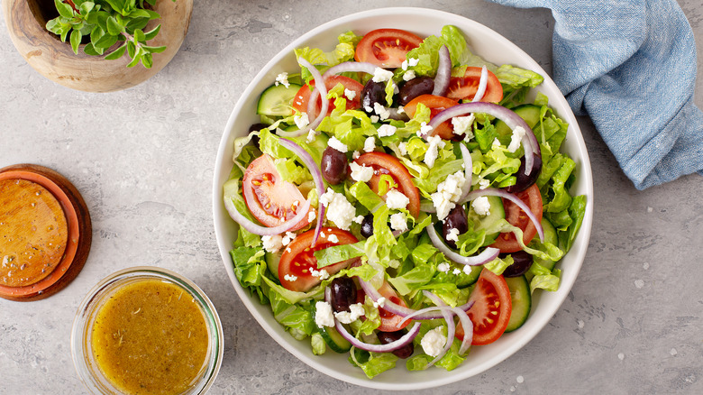 dressing next to bowl of salad
