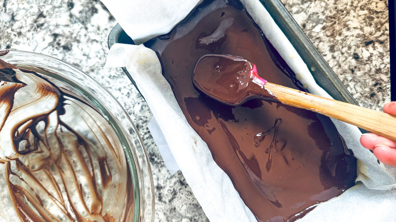 hand sticking spatula in chocolate