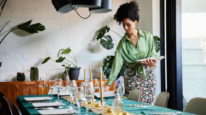 Person setting a dinner table