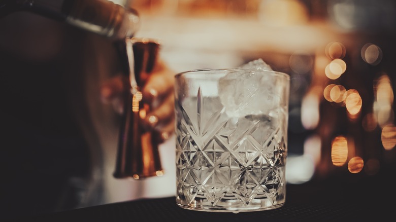 glass of ice with jigger in background