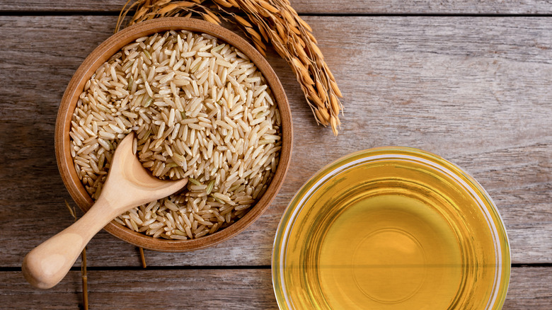 A bowl of brown rice with a bowl of oil