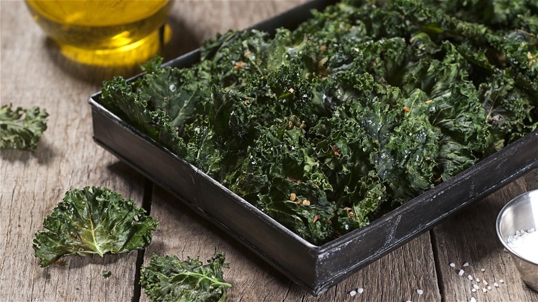 Kale chips on dark baking tray 