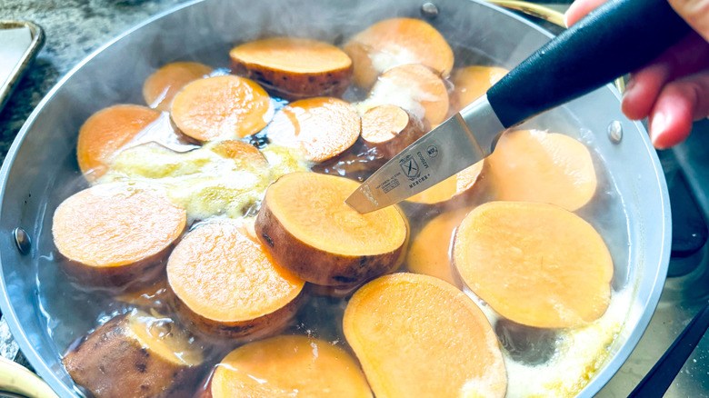 testing sweet potatoes with knife