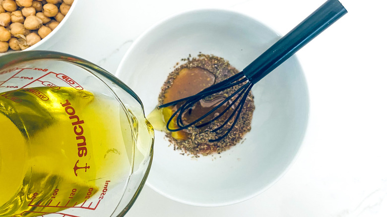 pouring oil into salad dressing