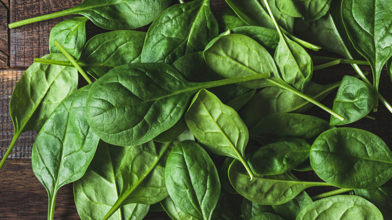 baby leaf spinach on wooden board