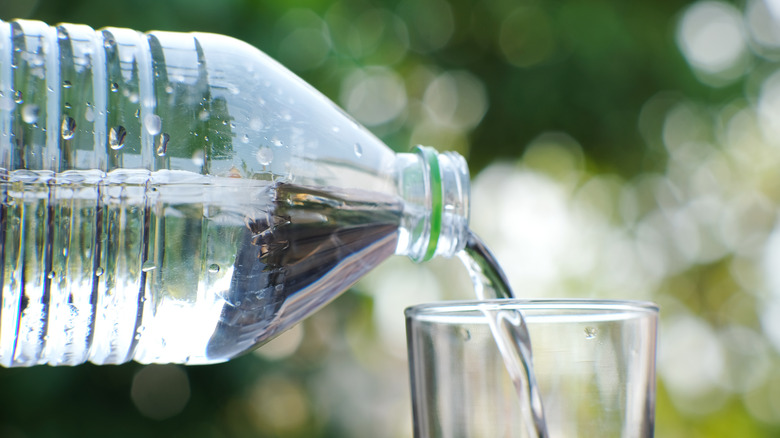 Bottled water being poured into a glass 