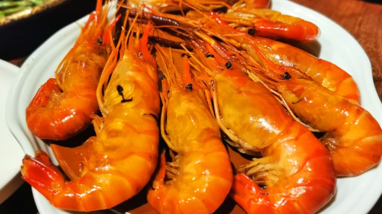A plate of cooked shrimp with heads on