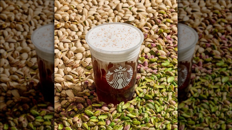 a starbucks pistachio latte on a background of pistachio notes