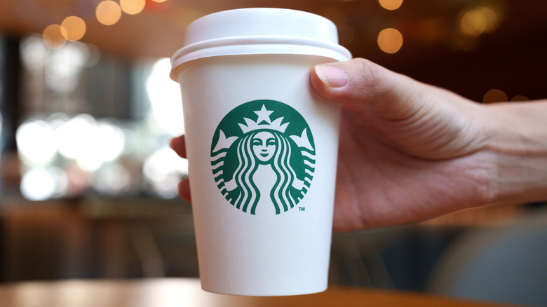 Person holding a reusable Starbucks cup