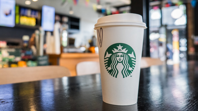 A Starbucks drink container sitting on a table inside a store location