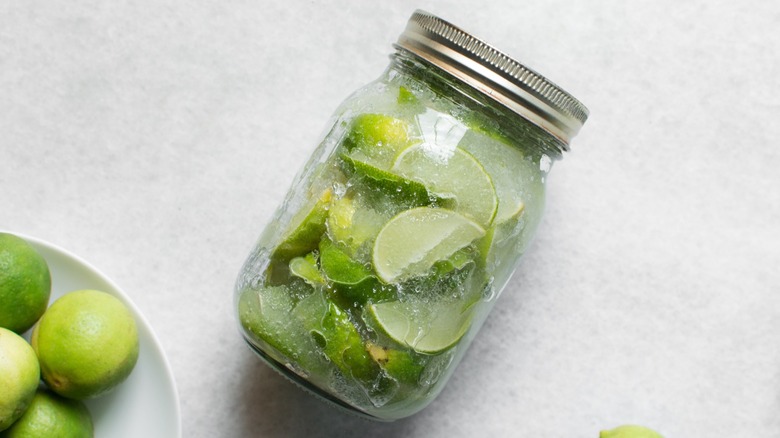 lime wedges in a mason jar with preserving ingredients