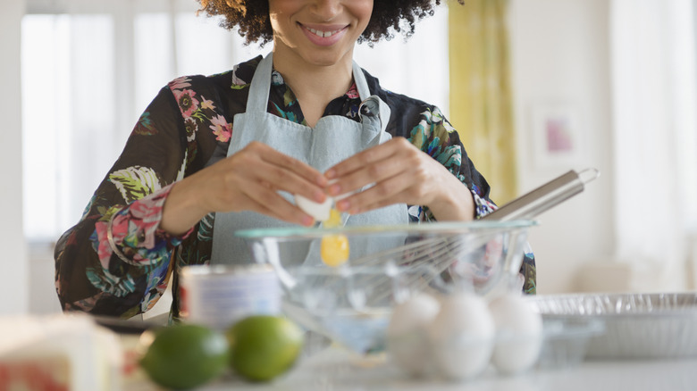 woman making key lime pie in kitchen with ingredients on counter