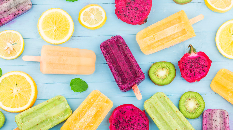 popsicles and fruit on a blue board 
