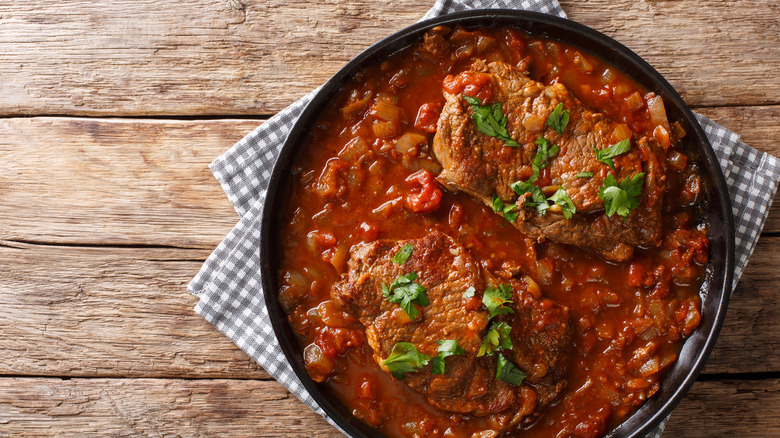 swiss steak in skillet on wooden table
