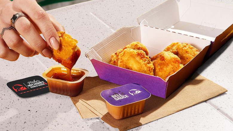 Hand dips chicken nugget in Diablo Sauce