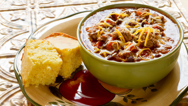 Chili topped with shredded cheese and a side of cornbread