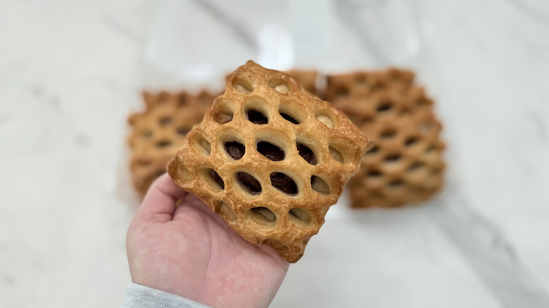 A hand holding a strawberry rhubarb pastry