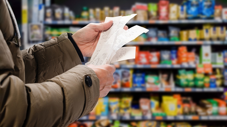 A person holding up a receipt 
