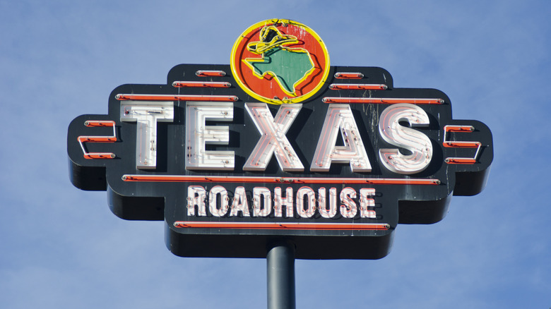 Exterior signage for Texas Roadhouse against a blue sky