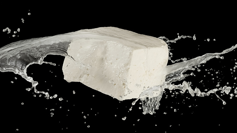 Feta against black background with brine