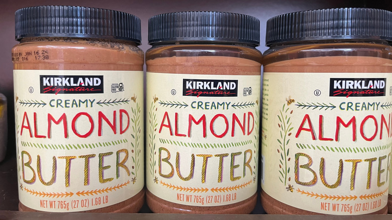 The containers of Kirkland Signature Creamy Almond Butter on a shelf.