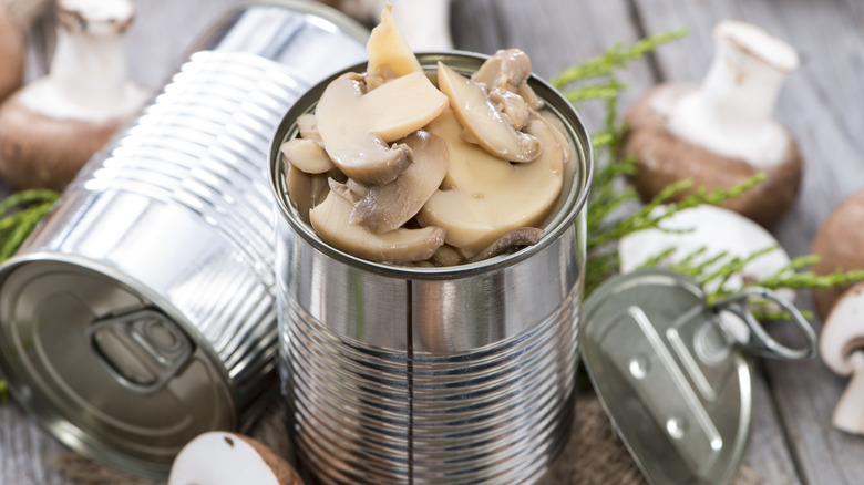 canned mushrooms on wooden board