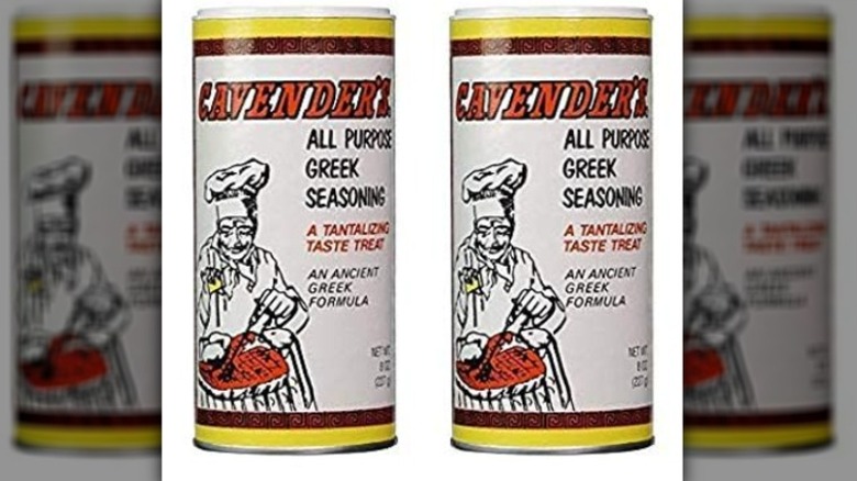 Isolated on a white background are two containers of Cavender's All Purpose Greek Seasoning