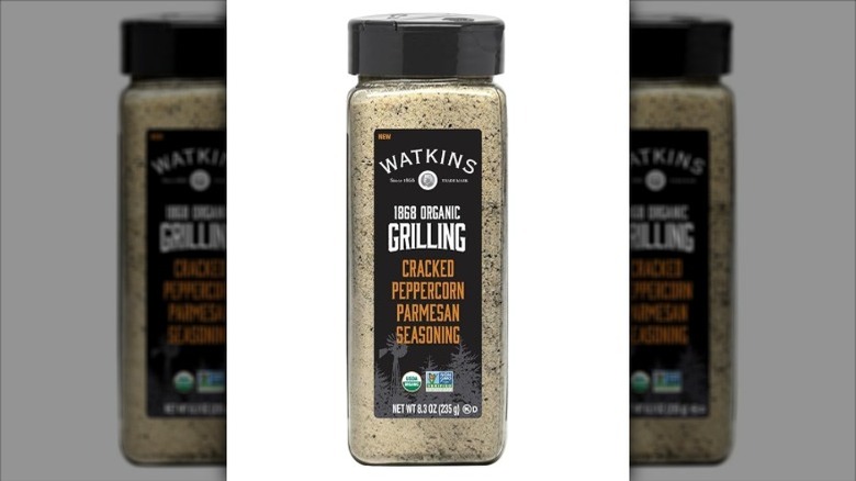 Isolated on a white background is a container of Watkins Cracked Peppercorn Parmesan Seasoning