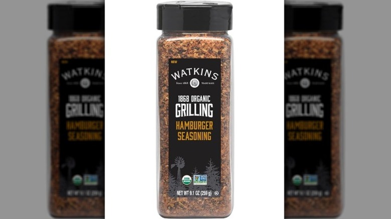 Isolated on a white background is a container of Watkins 1868 Organic Grilling Hamburger Seasoning