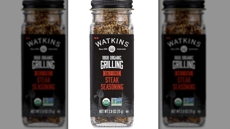 Isolated on a white background is a container of Watkins Salt-Free Steak Seasoning