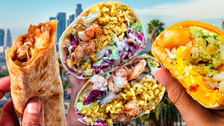 Hands holding burritos