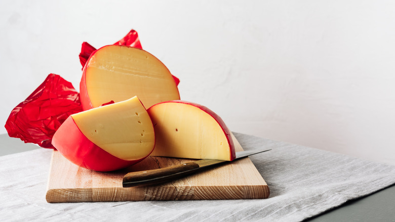 Sliced blocks of Edam cheese on a wooden cutting board