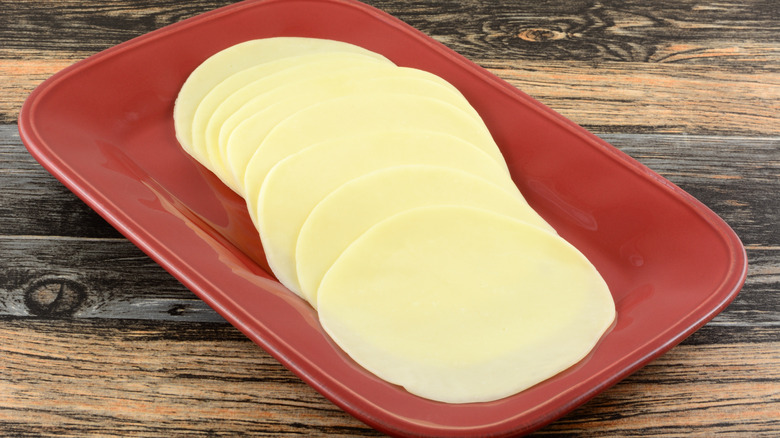 Slices of provolone cheese in a red dish