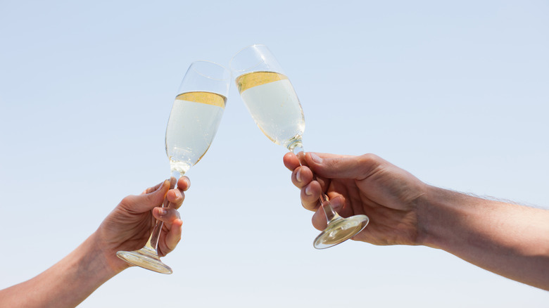Two hands holding and clinking glasses