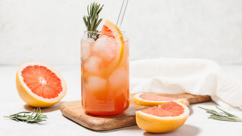 Cocktail with sliced grapefruit and rosemary sprigs