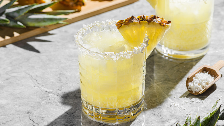 Pineapple cocktail with a desiccated coconut rim and pineapple wedge garnish