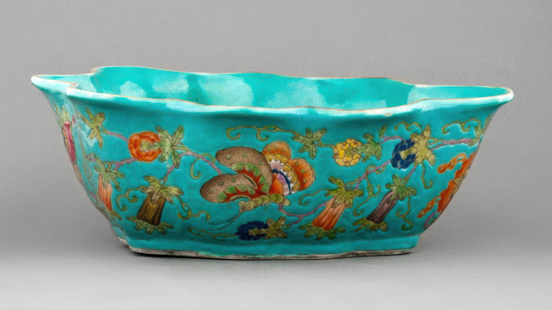 A decorative bowl in blue with fun designs isolated on a gray background