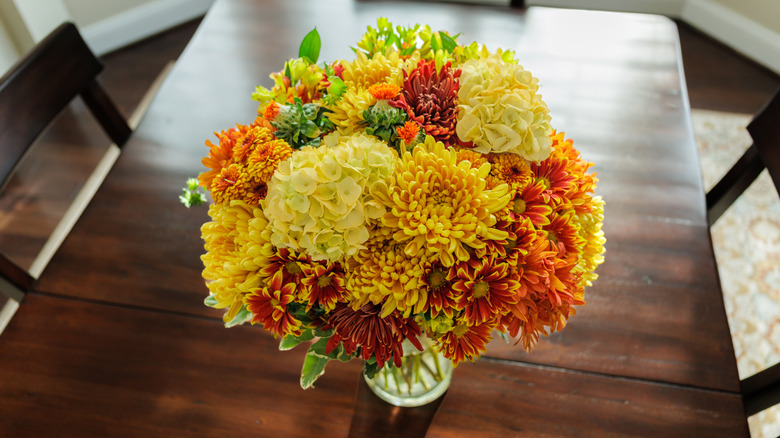Top view of a floral centerpiece on a brown wood table