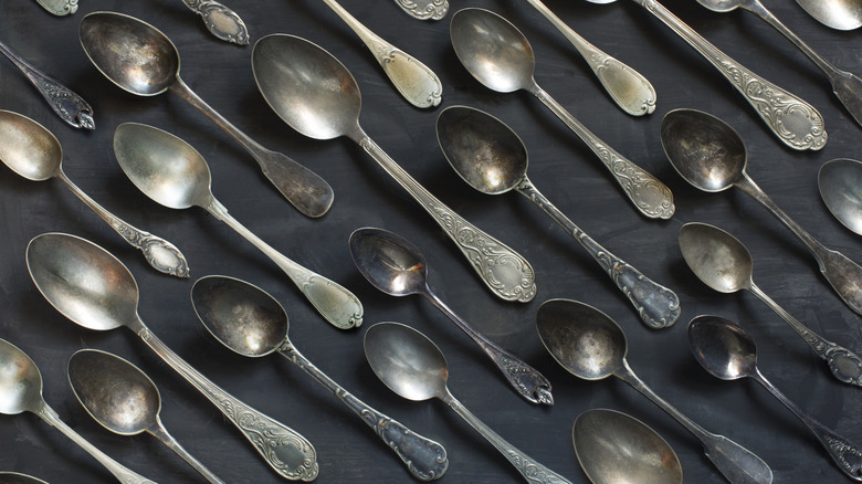A group of vintage spoons on a  black background