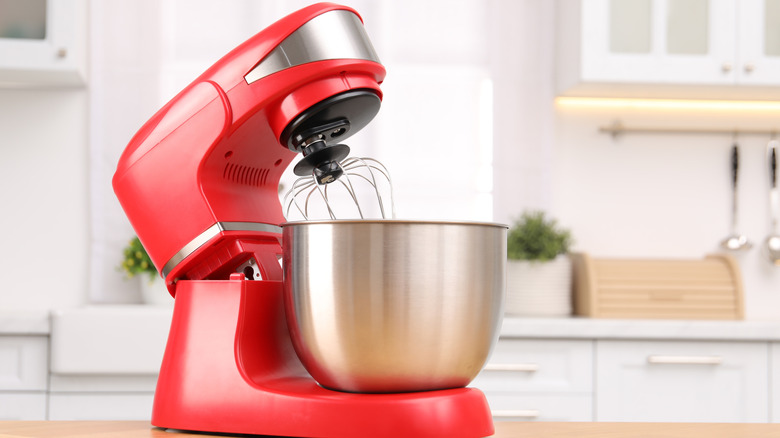 A pretty red stand mixer with a stainless steel  bowl