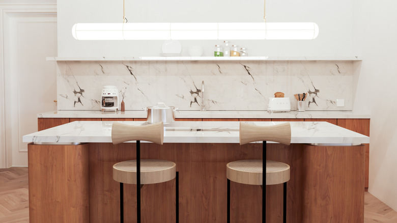 A wooden kitchen island with a white marble countertop