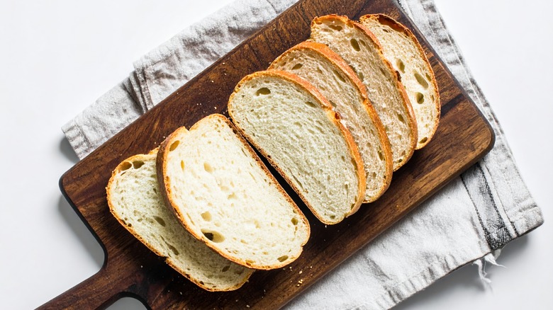 Homemade fresh bread, sliced, on a wooden board